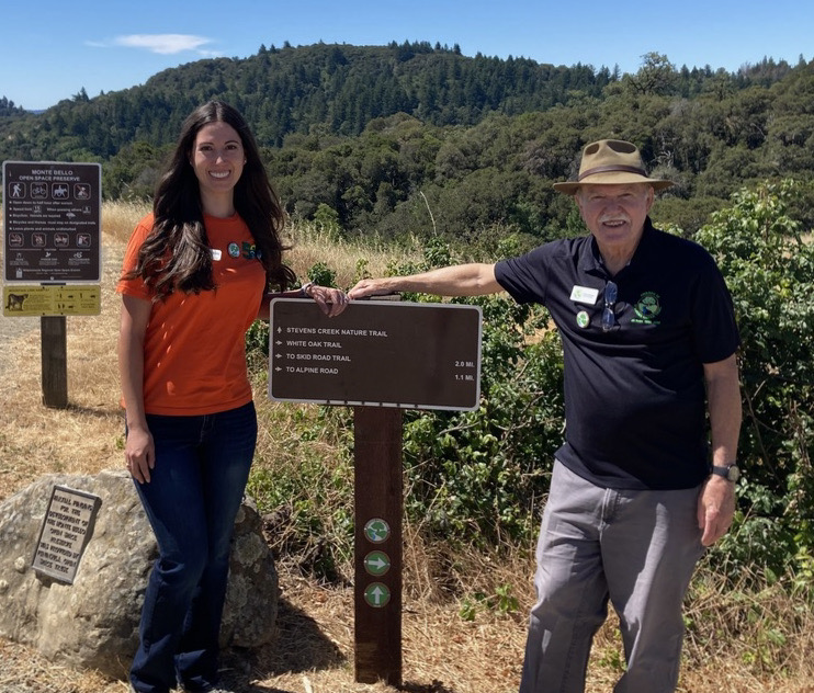 Photo of Melissa and Greg by post with Stevens Creek Trail medallion and directional arrows 
